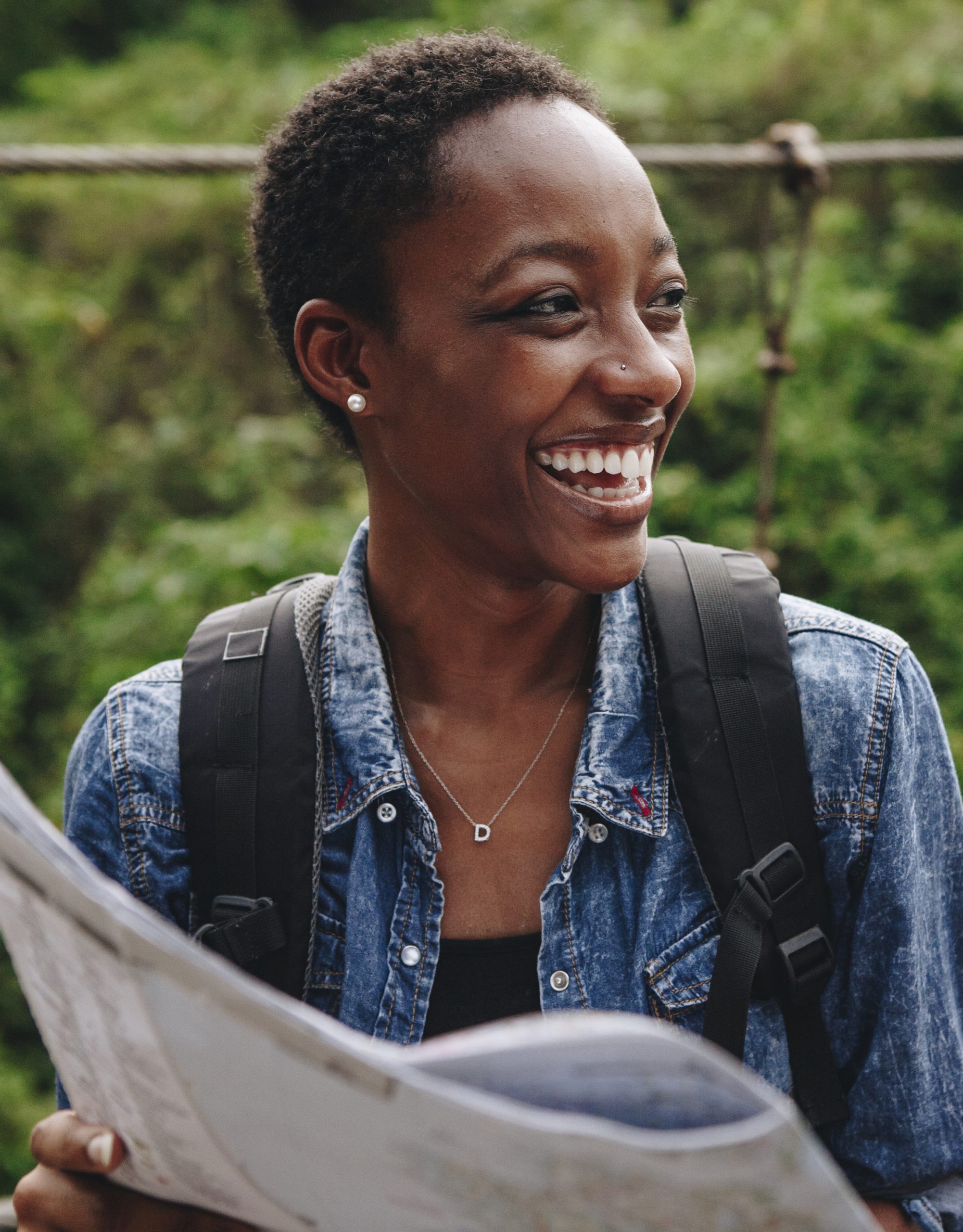 Happy smiling black woman navigating with a map on SelfishMe Travel