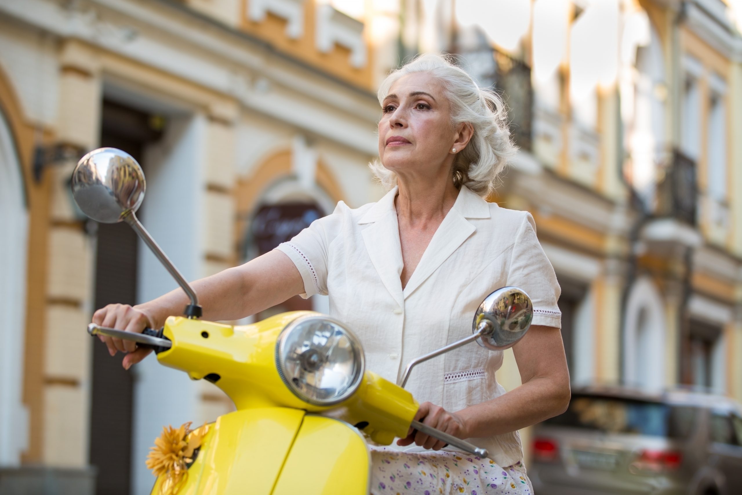 Mature white Woman on yellow scooter on SelfishMe Travel