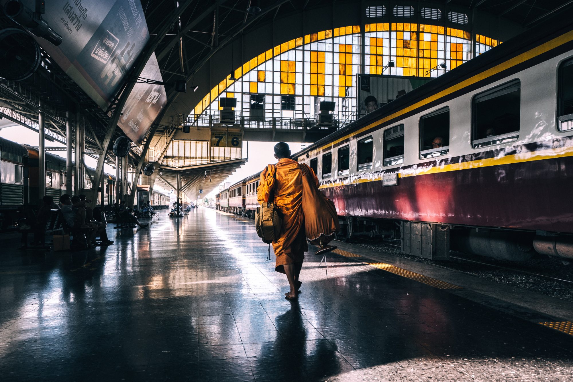 Monk walking on train station platform in Bangkok Thailand on SelfishMe Travel LLC