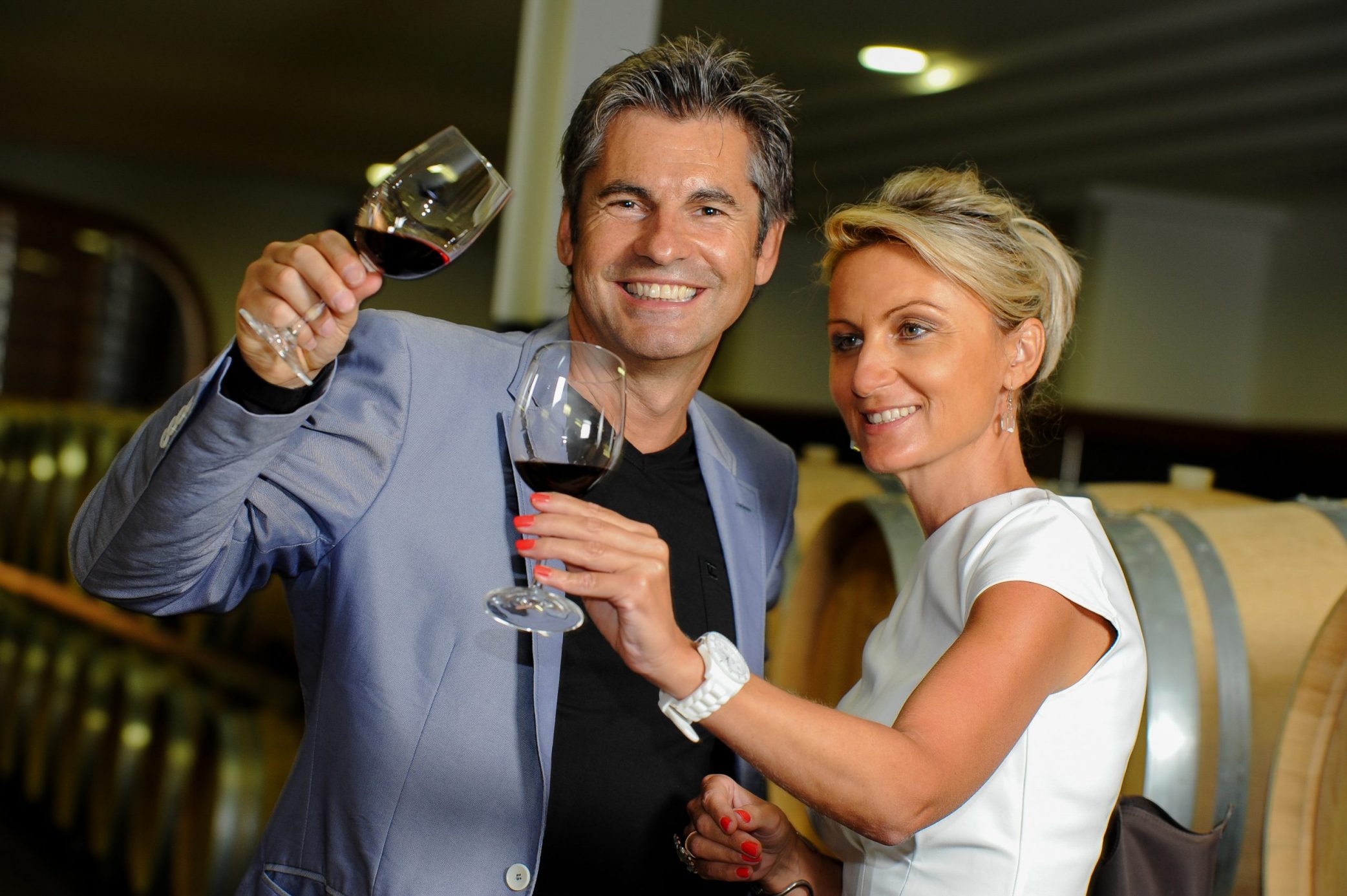 Couple tasting red wine in a wine cellar on SelfishMe Travel LLC